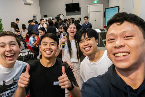 Grads and uni students talking in small groups at Campus Time
